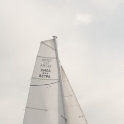 white sail of modern yacht against overcast sky